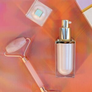 Luxury skincare product display with a rose quartz roller in a studio setting.
