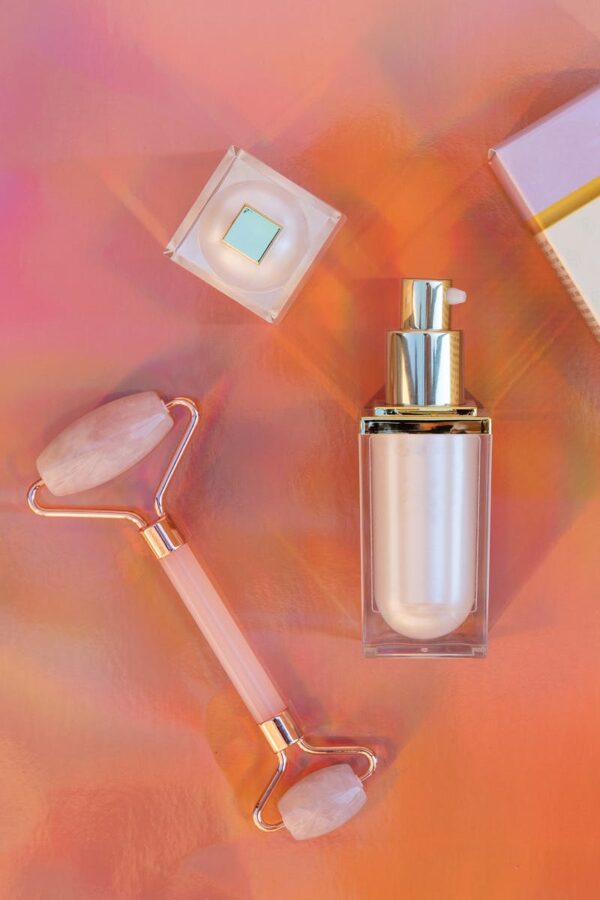 Luxury skincare product display with a rose quartz roller in a studio setting.